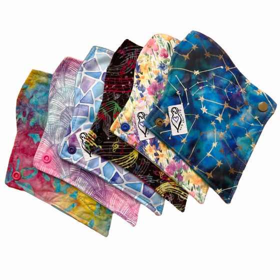 A set of six assorted tapered mini pads with various colorful patterns, against a white background. The Pads are curved at the top and tapered at the bottom.