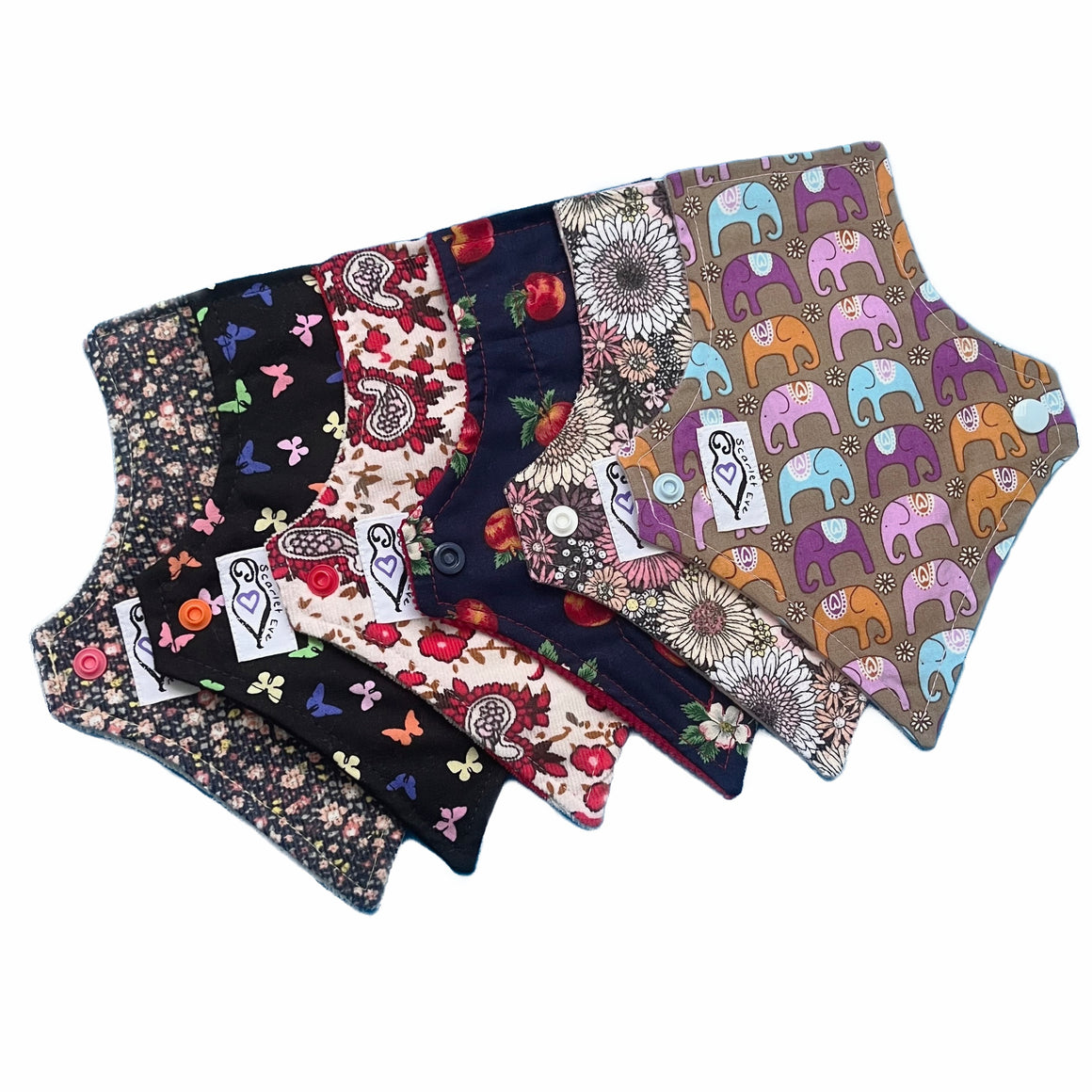 A set of six assorted tapered panty liners with various colorful patterns, against a white background. The Pads are squared at the top and tapered at the bottom.