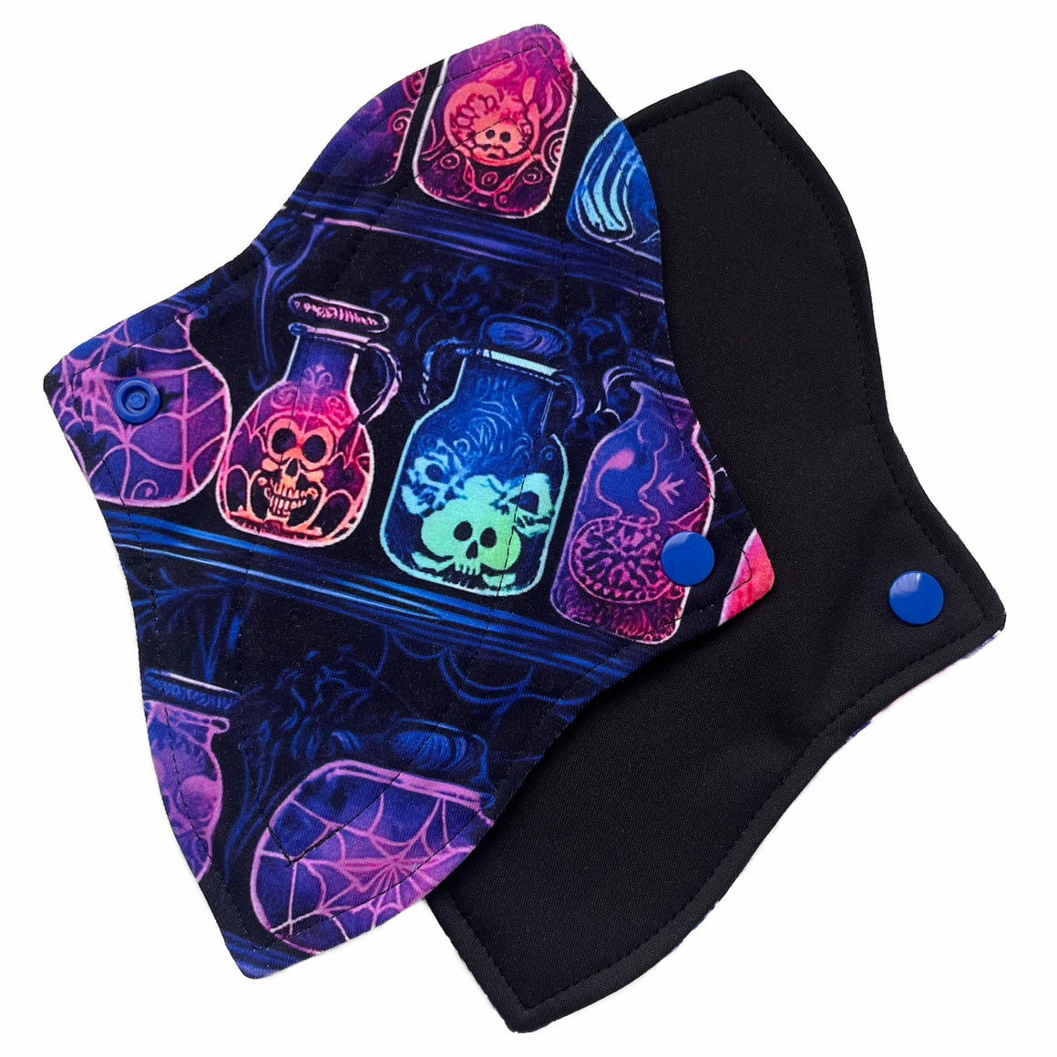 Two reusable menstrual pads with a contoured shape against a white background. The pad on top is made from black cotton Lycra with potion bottles in neon colours. The pad on the bottom is made from black PUL fabric and has a white "Scarlet Eve" label.