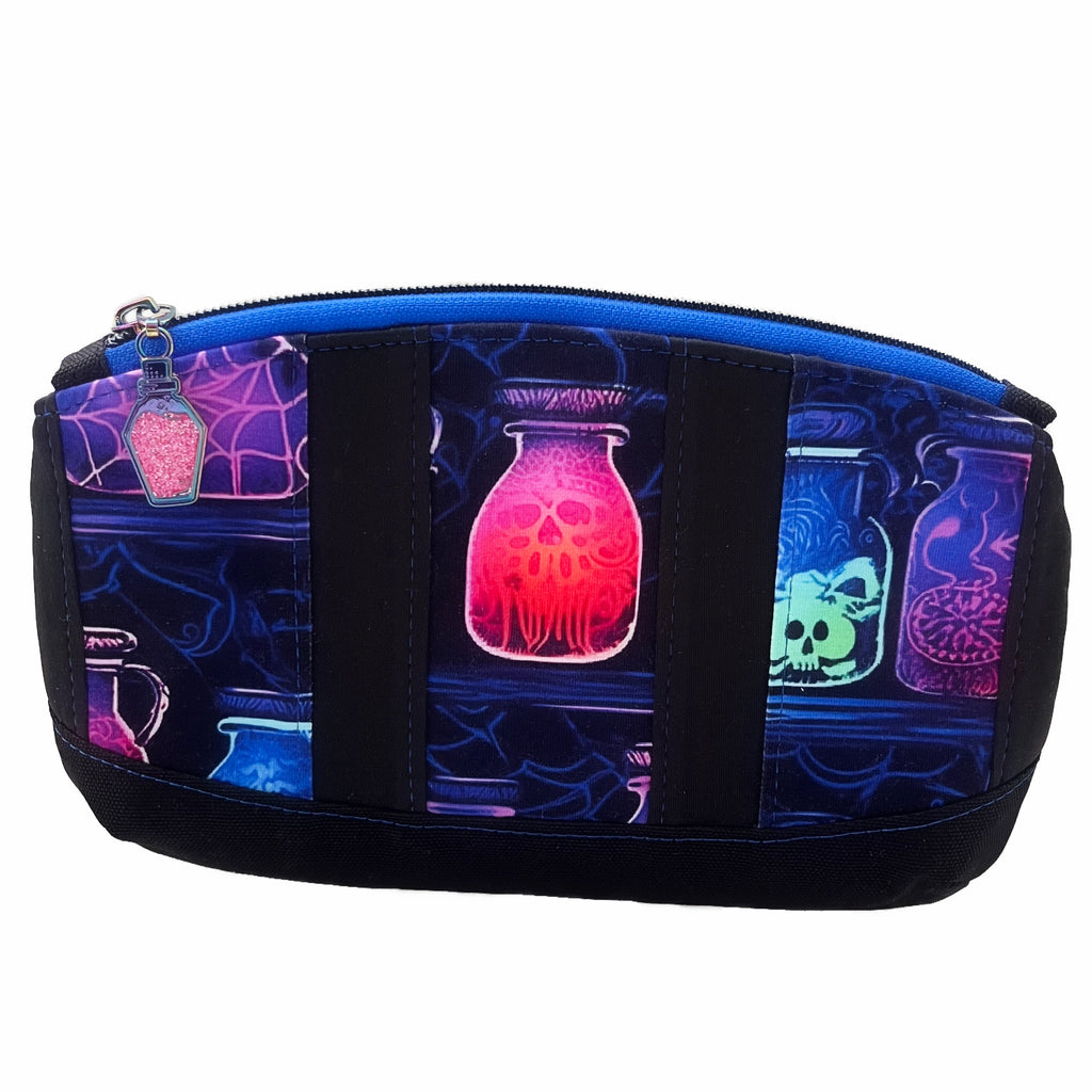 A zippered pouch against a white background. Pouch has stripes of neon potions and black PUL fabric, with a black canvas base. A royal blue zipper with an iridescent and pink glitter potion zip pull.