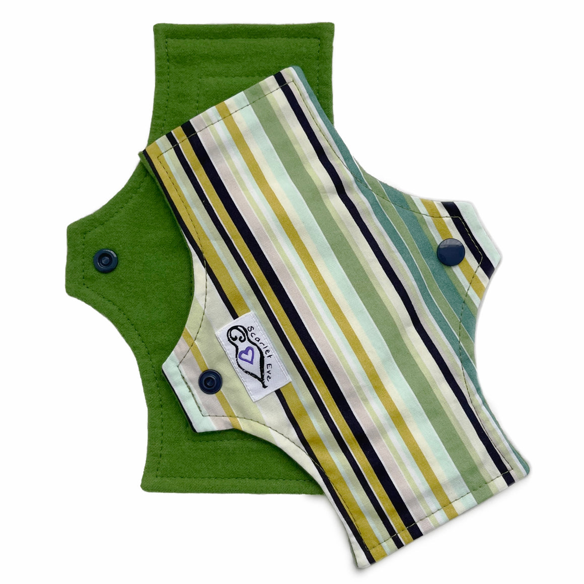 Two reusable panty liners against a white background. The Pad on top is made from multicoloured cotton fabric, with stripes of different shades of green, blue and white, with a white 'Scarlet Eve' label. The Pad underneath is made from green flannel fabric.