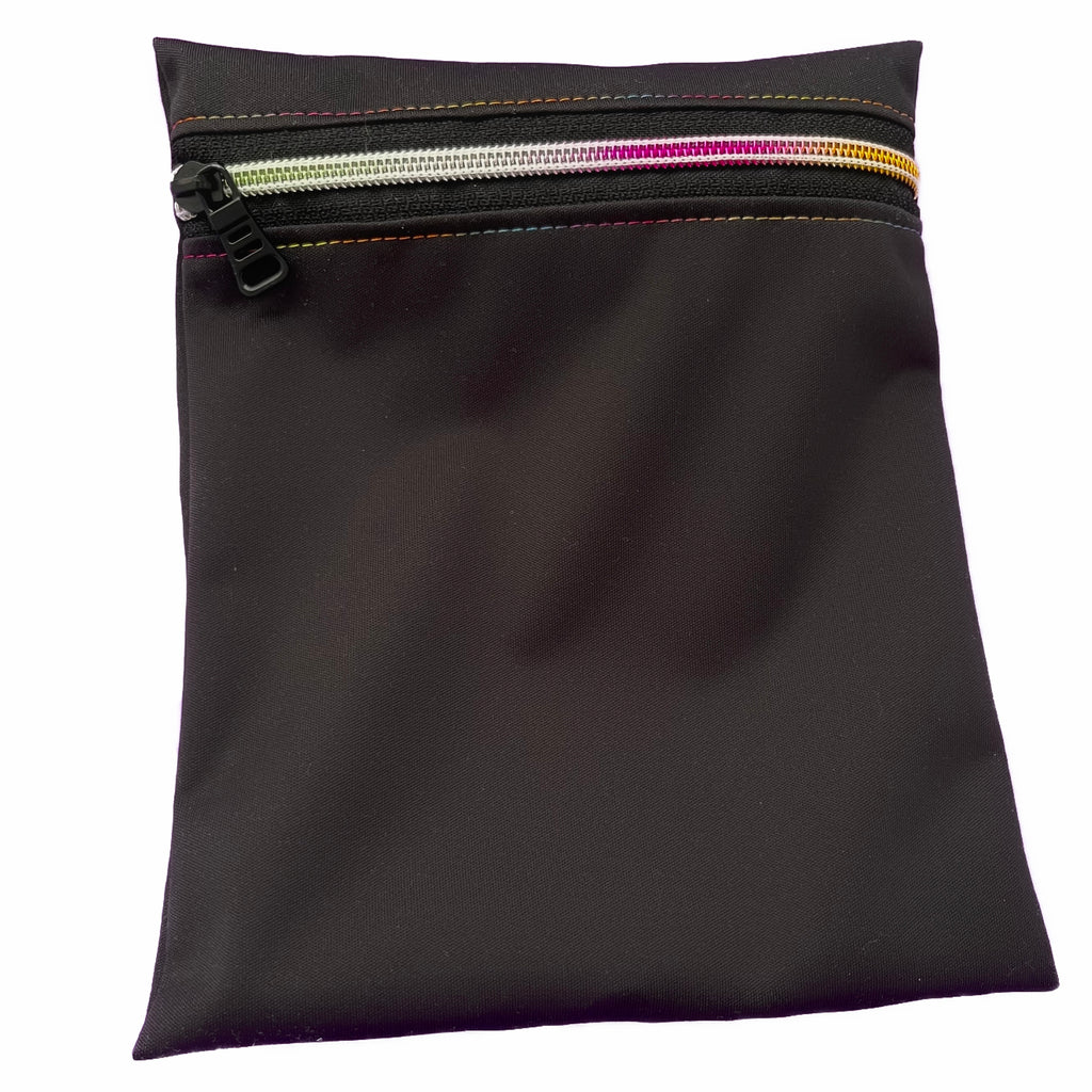 A rectangular zippered pouch against a white background. The wet bag is made from black PUL fabric. A variegated rainbow zip runs along the pouch towards the top.