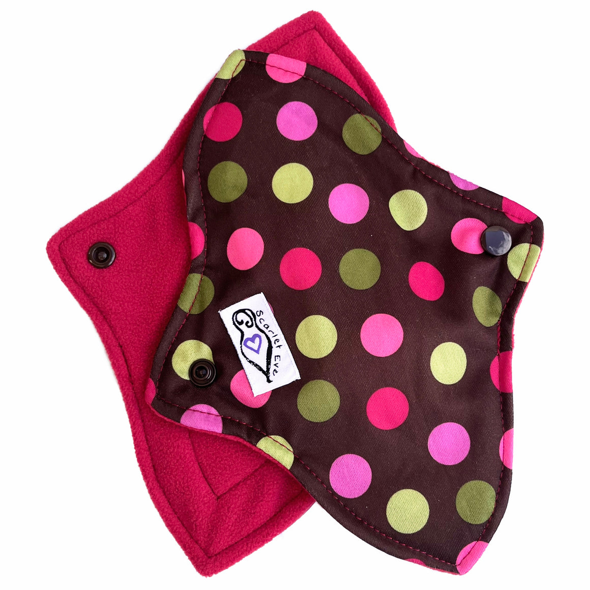 Two reusable menstrual pads with contoured shape, against a white background. The pad on top is made from chocolate brown PUL fabric with pink and green spots . The pad on the bottom is made from raspberry red microfleece fabric.