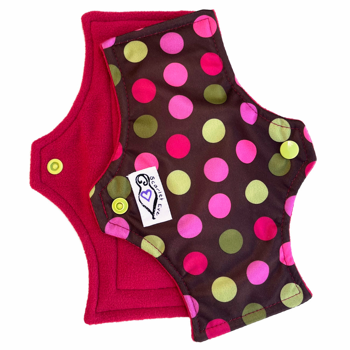 Two reusable menstrual pads with squared top and flared bottom shape, against a white background. The pad on top is made from chocolate brown PUL fabric with pink and green spots . The pad on the bottom is made from raspberry red microfleece fabric.