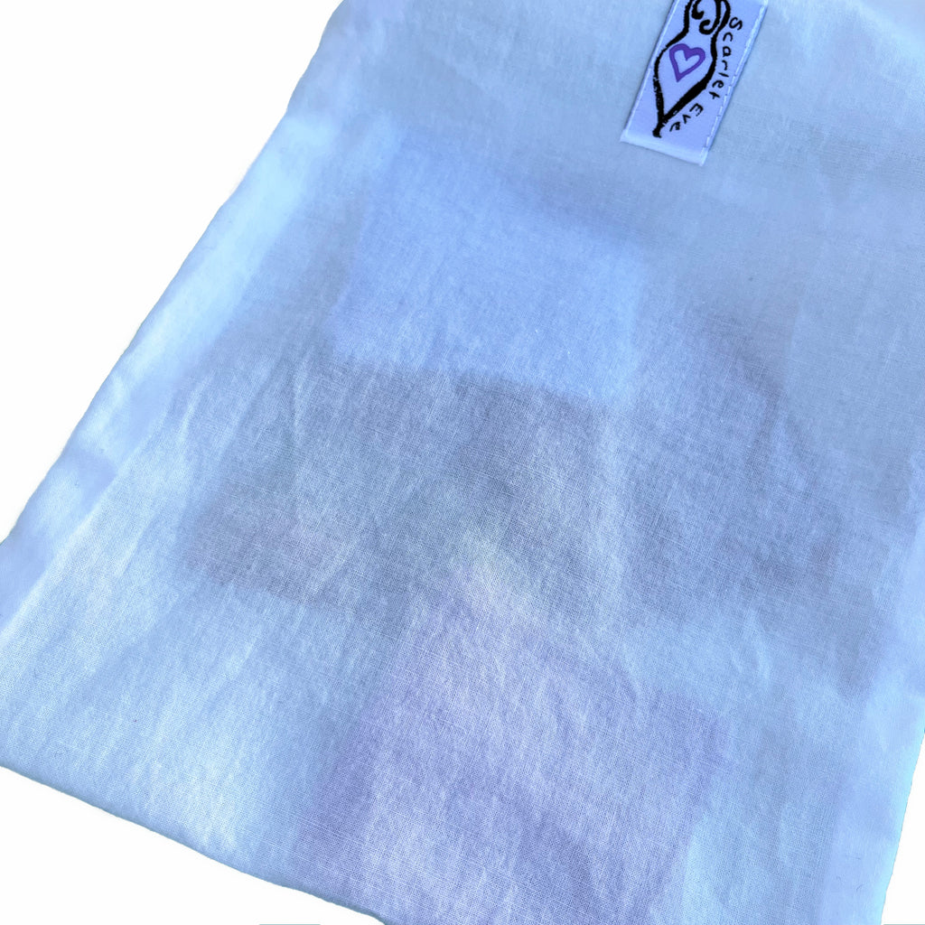 Scarlet Eve Cotton Wash Bag3. Thin, white cotton wash bag with Deluxe face wipes inside.
