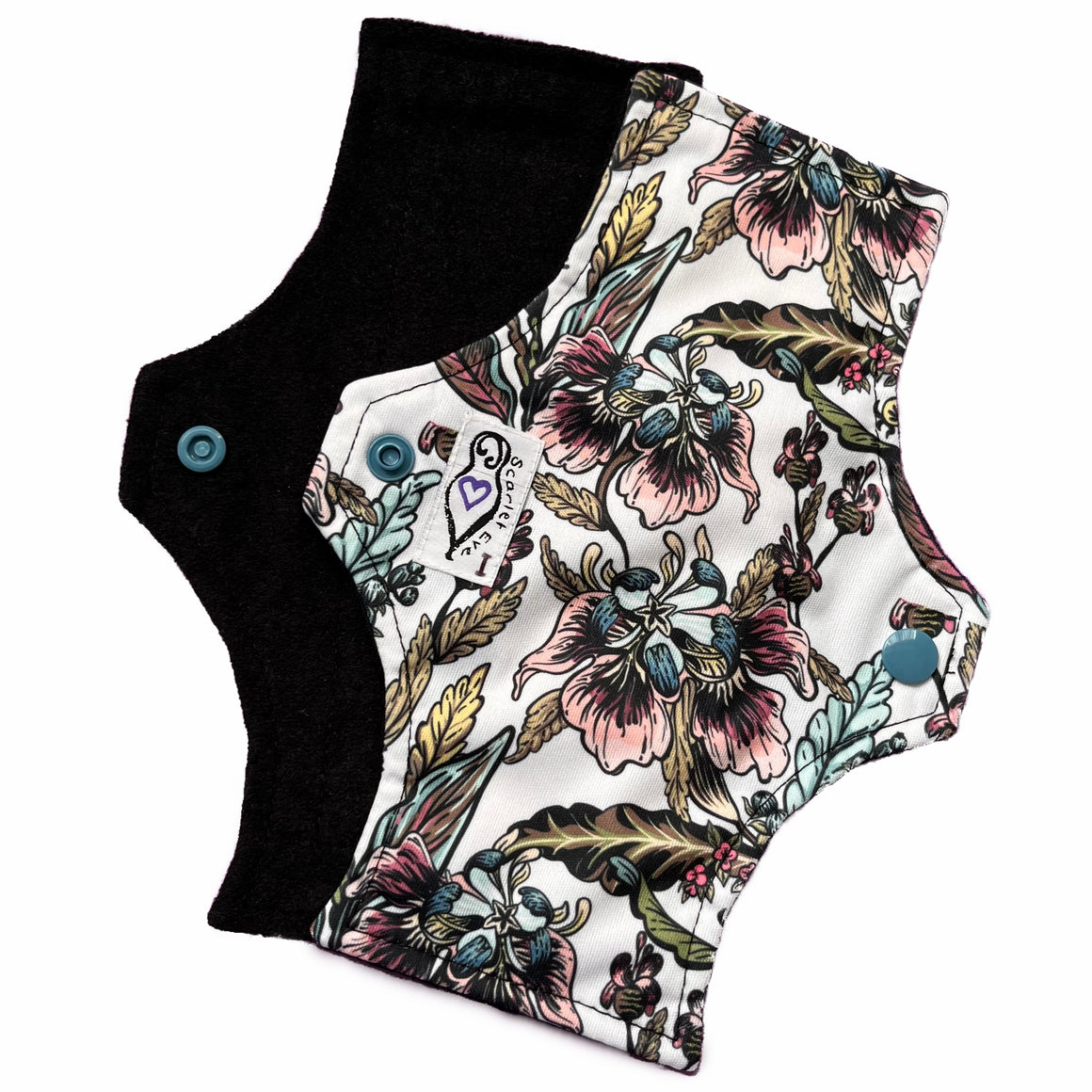 Two reusable menstrual pads with squared top and flared bottom shape, against a white background. The pad on top is made from white PUL fabric with black and pastel floral print, and has a white "Scarlet Eve" label with an "I" on it. The pad on the bottom is made from black suedecloth.