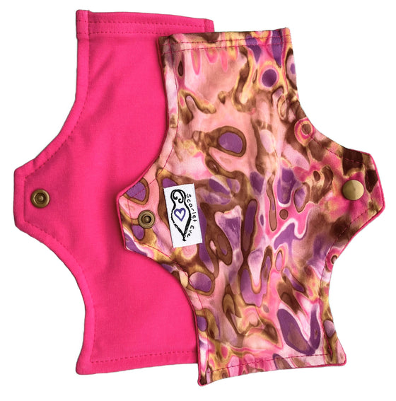 Scarlet Eve Neapolitan New Woman Pad. Top: Solid Fuschia Pink Cotton Lycra. Back: Pink, Purple, Brown and Gold painted swirls PUL. 3 layer flip out bamboo fleece booster. New Woman Pads have been designed with the young teen in mind.
