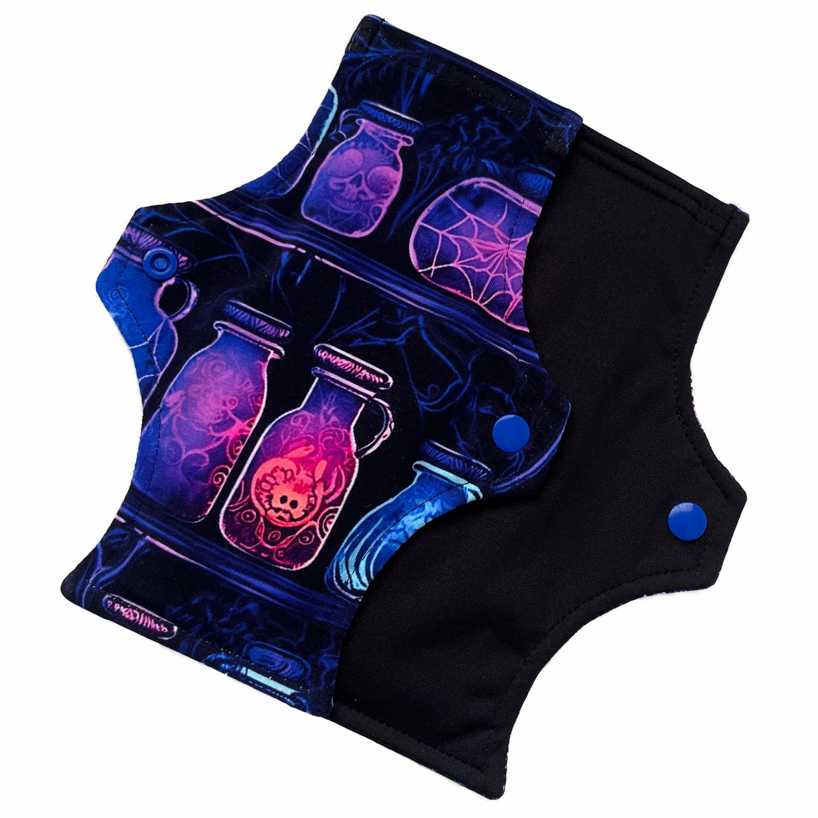 Two reusable menstrual pads with a squared top and flared bottom shape against a white background. The pad on top is made from black cotton Lycra with potion bottles in neon colours. The pad on the bottom is made from black PUL fabric and has a white "Scarlet Eve" label.