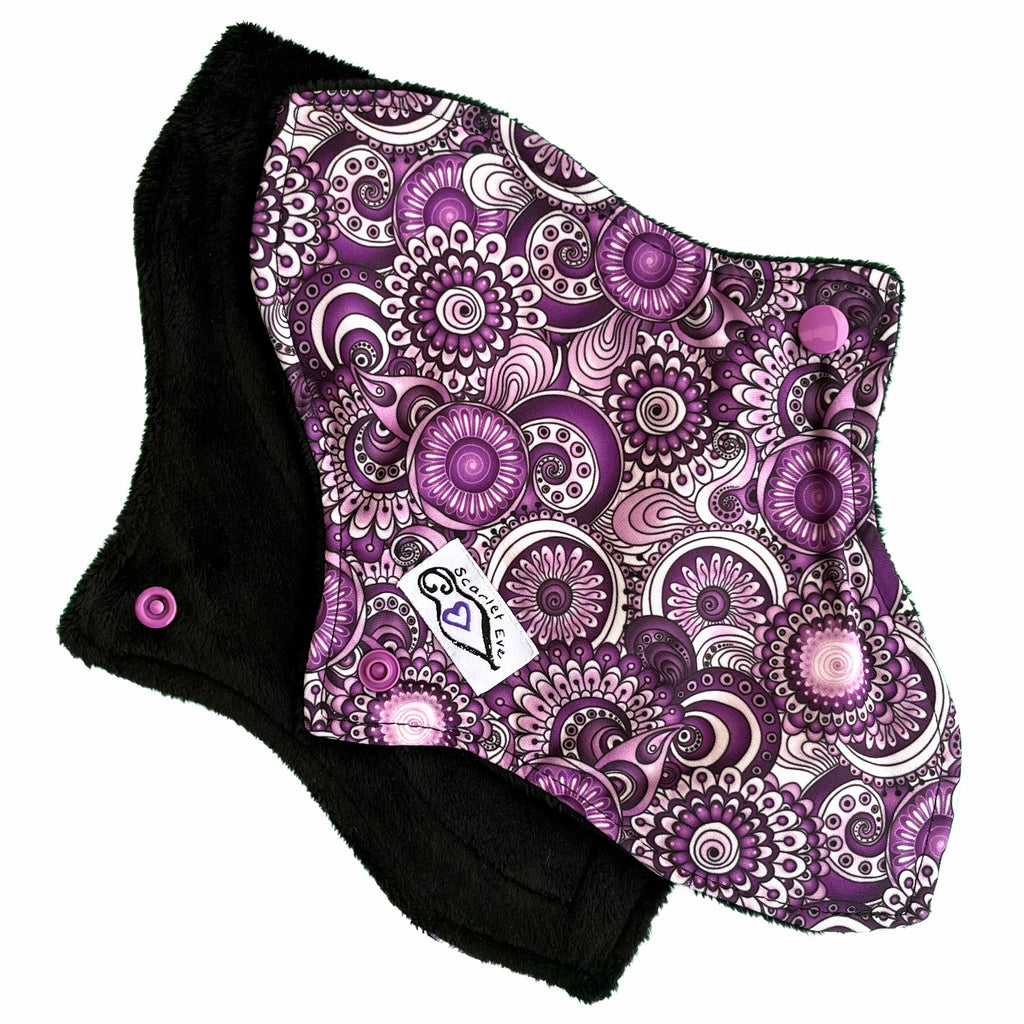 Scarlet Eve Purple Floral Curvy Pad. Top: Plush Black Minky. Bottom: Purple, Black and White Floral PUL. 2 layer bamboo fleece booster sewn in. Contoured shape for snug, form-fitting comfort and coverage without bulk.