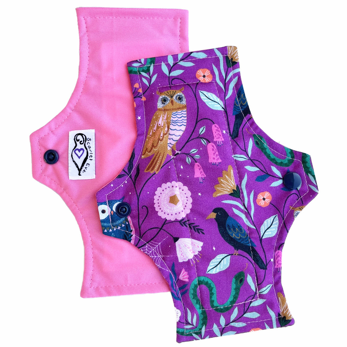 Three reusable menstrual pads with squared top and flared bottom shape, against a white background. The pad on top is made from purple woven cotton with owls, a crow, a snake and leaves. The two pads underneath are made from turquoise PUL fabric with a white "Scarlet Eve" label, and pink PUL fabric with a white "Scarlet Eve" label.