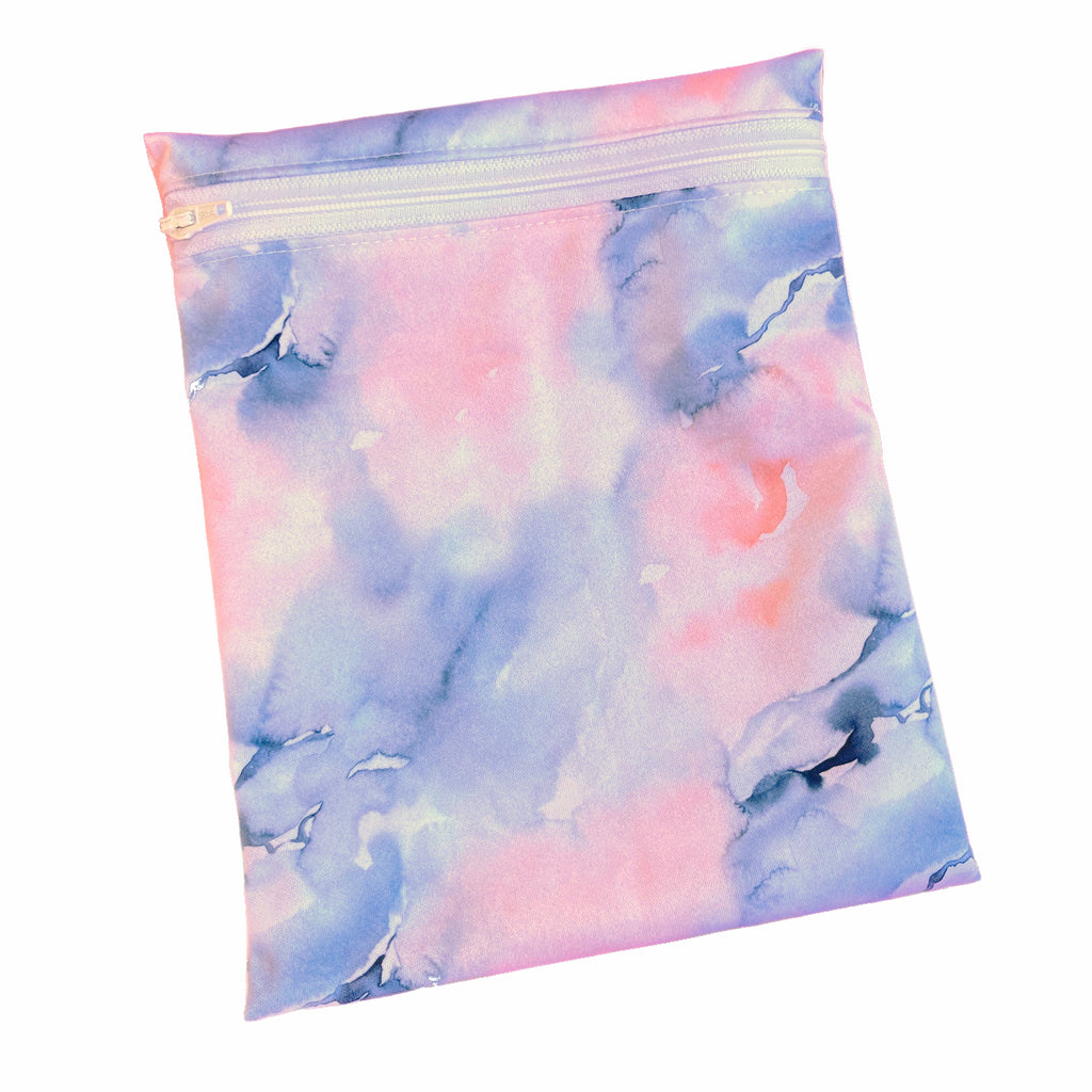 A rectangular zippered pouch against a white background. The wet bag is made from printed PUL fabric with watercolour navy and apricot print. A white coloured zip runs along the pouch towards the top.