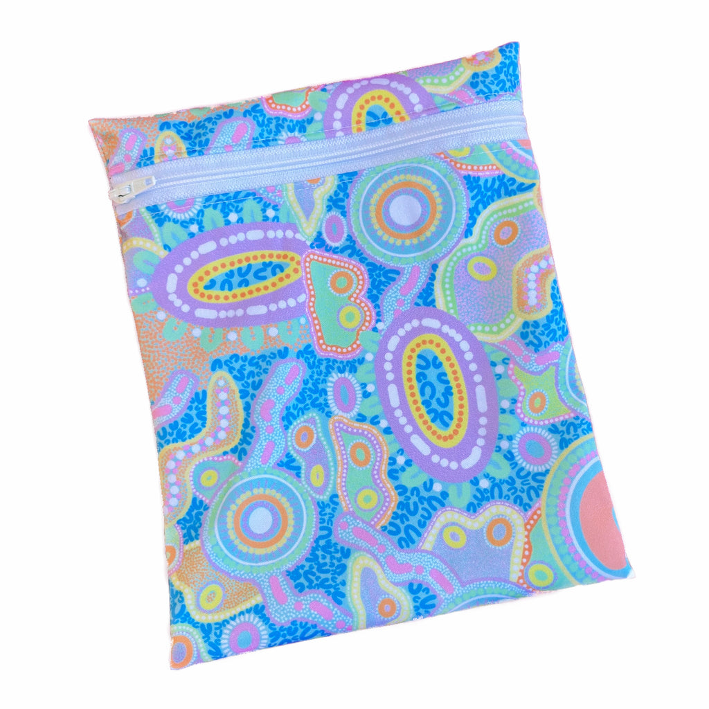 A rectangular zippered pouch against a white background. The wet bag is made from printed PUL with bright pastel First Nations artwork. A white coloured zip runs along the pouch towards the top.