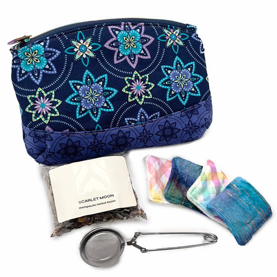 A collection of self care products and accessories including pouch, tea leaves, tea infuser and face wipes, displayed on a white background.