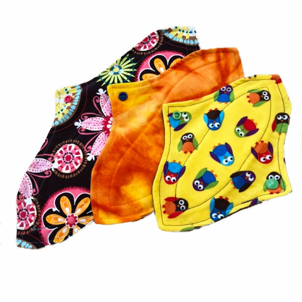 A set of three assorted curvy pads with various colorful patterns, against a white background. The Pads all have the same contoured shape and are three different sizes.
