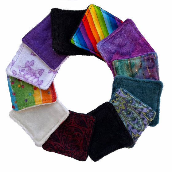 12 small square face wipes in a variety of colours arranged in a circle against a white background. Some wipes have velour facing up and some wipes have flannel facing up.