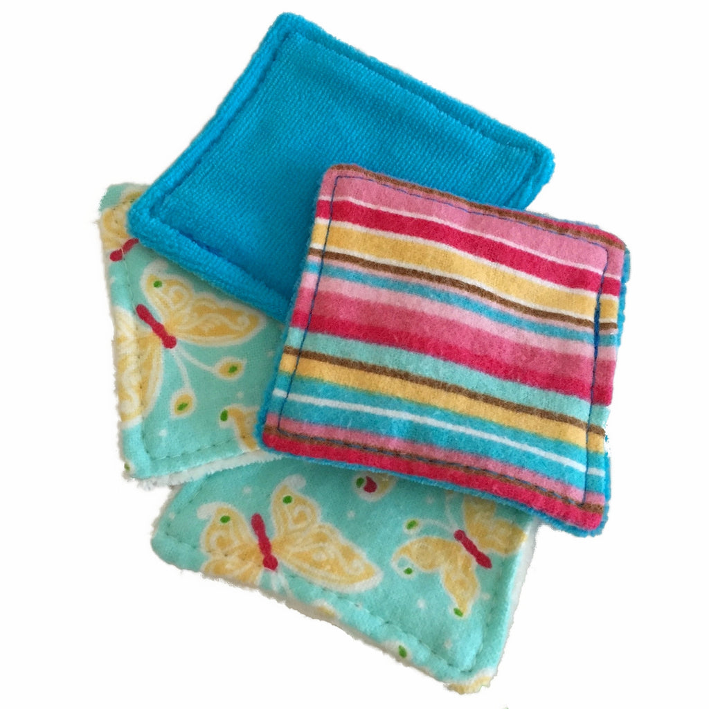 A set of 4 small square wipes, made from various flannel and velour fabrics, against a white background. The wipes are spread out to show the printed flannel and velour fabrics.
