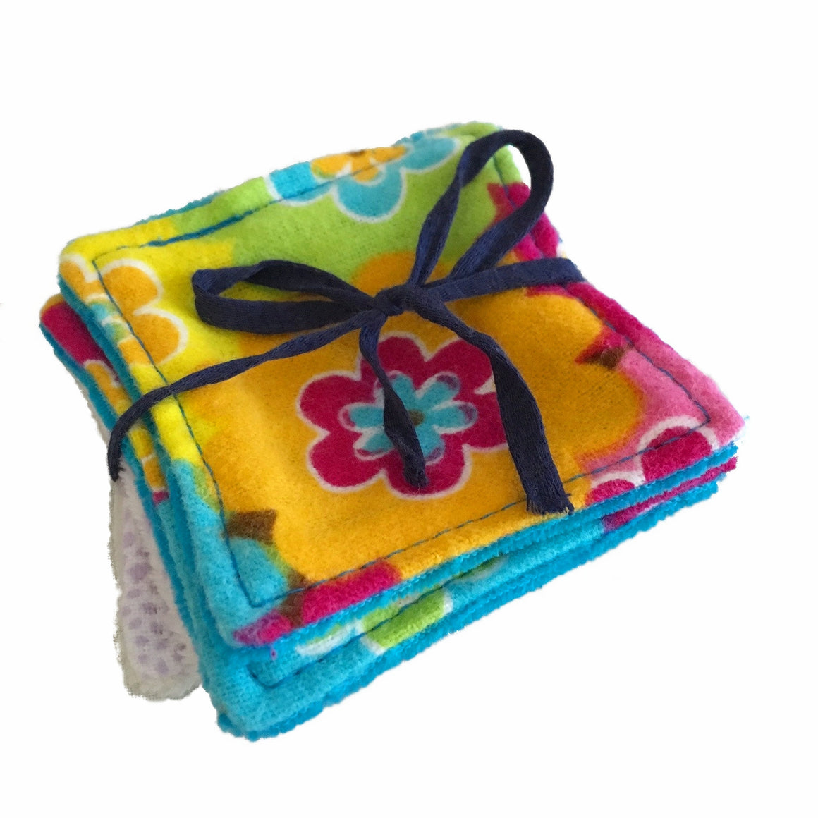 A set of 4 small square wipes, made from various flannel and velour fabrics, against a white background. The wipe on top has a bright floral print. The wipes are laying flat and are tied with a navy blue bow.