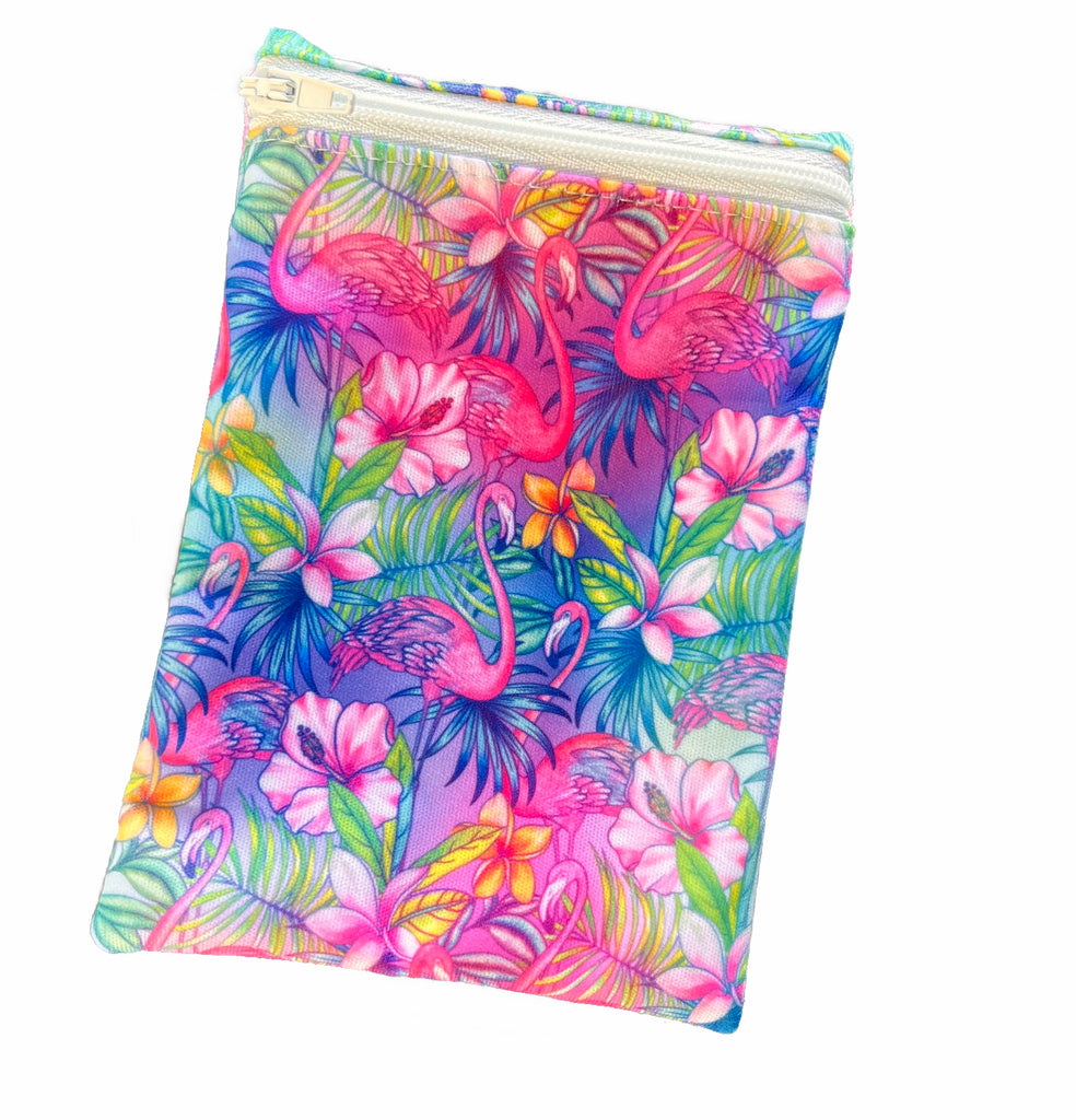 A rectangular zippered pouch against a white background. The wet bag is made from light blue PUL fabric with a bright, tropical flamingos print. A light blue coloured zip runs along the pouch towards the top.