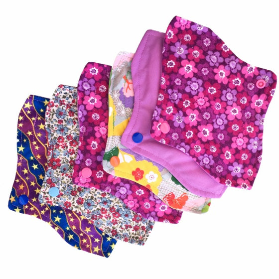 A set of six assorted curvy mini pads with various colorful patterns, against a white background. The Pads have a contoured shape.