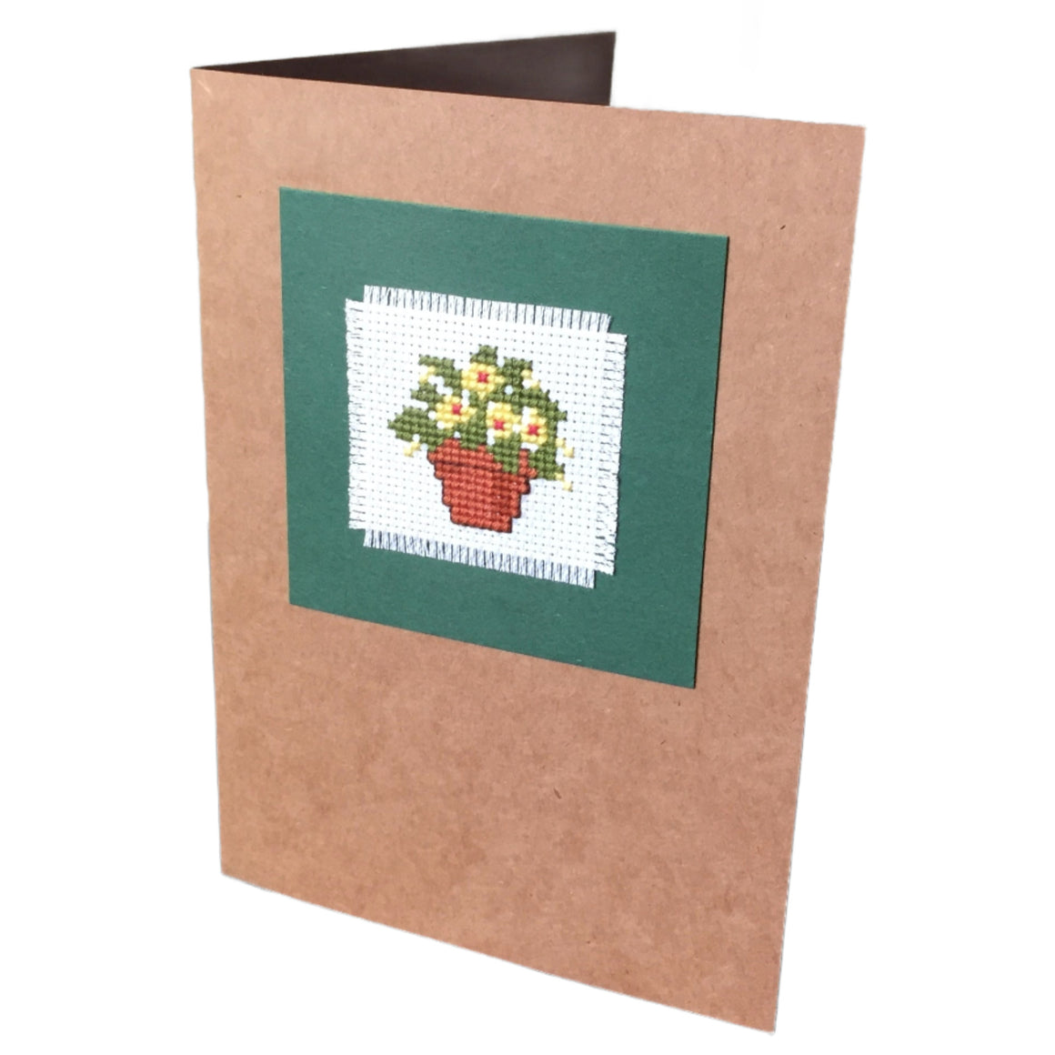 A handcrafted cardboard gift card with a cross stitch design featuring a pot of yellow flowers, mounted on a brown card.