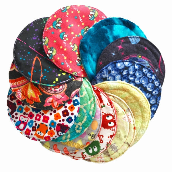 A selection of nursing pads with various colorful patterns, arranged in a circle, against a white background.