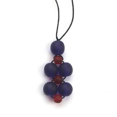 A necklace made from a cluster of purple and red beads on black necklace thread, against a white background. 