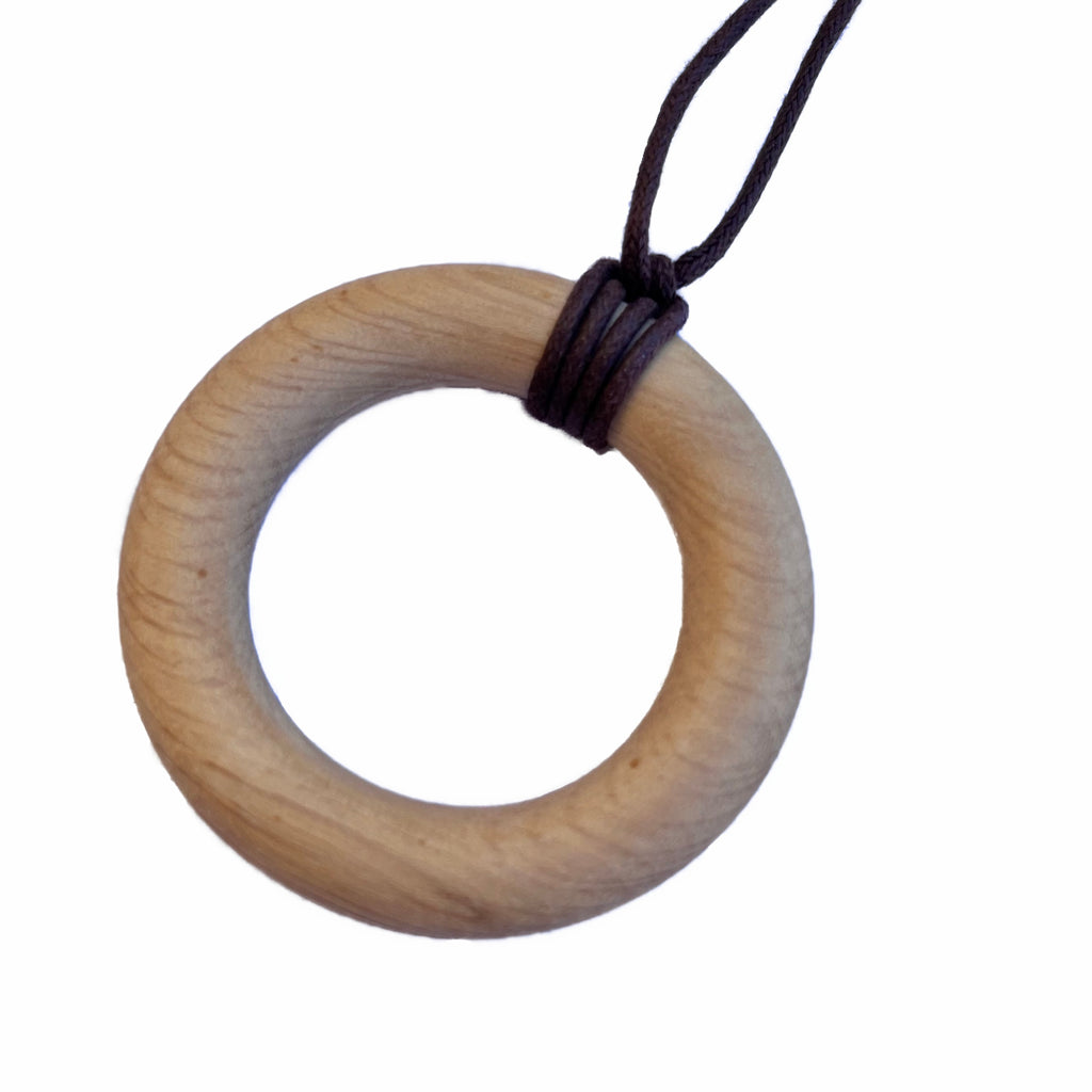 A brown wooden ring with dark brown necklace thread, against a white background.