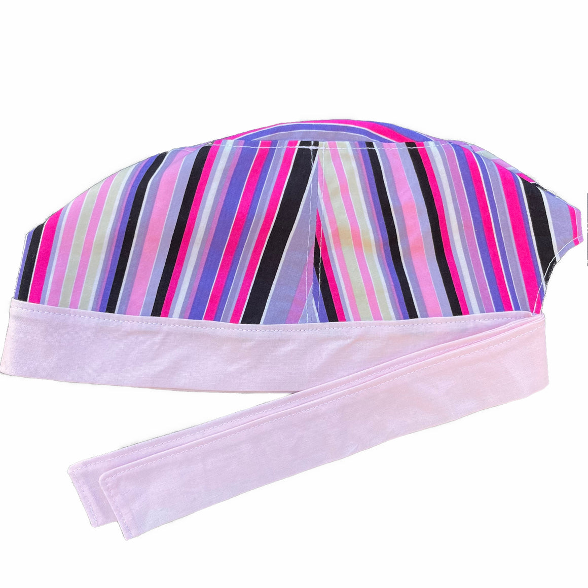 A pink and purple scrub cap against a white background. The main part of the cap is made from woven cotton with purple, pink, black and light yellow stripes. The bottom band and ties are made from light pink woven cotton.