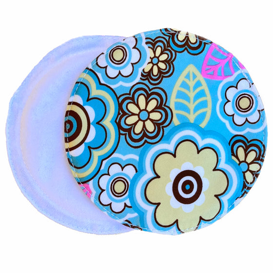 Two reusable nursing pads against a white background. The breast pad on top is made from turquoise PUL fabric with a brown, yellow and pink floral pattern. The breast pad on the bottom is made from white suedecloth fabric.