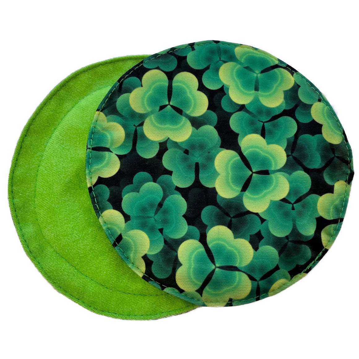 Scarlet Eve Shamrocks Breast Pads. Top: Solid bright lime green suedecloth. Back: PUL with lime and emerald green shamrocks on a dark green and black background. 2 layers bamboo fleece sewn in. Scarlet Eve breast pads have generous coverage and superior absorbency.