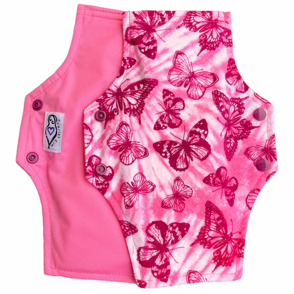 Two reusable menstrual pads with squared top and flared bottom shape against a white background. The pad on top is made from light pink and white tie dye cotton flannel with maroon butterflies. The pad on the bottom is made from raspberry pink PUL fabric and has a white "Scarlet Eve" label.