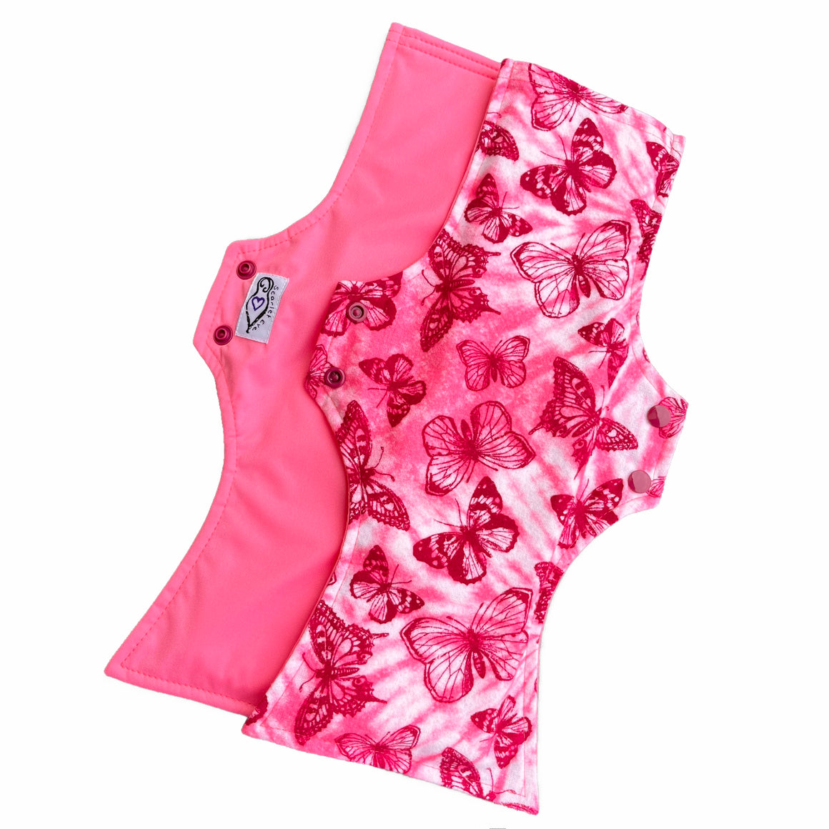 Two reusable menstrual pads with squared top and flared bottom shape against a white background. The pad on top is made from light pink and white tie dye cotton flannel with maroon butterflies. The pad on the bottom is made from raspberry pink PUL fabric and has a white "Scarlet Eve" label.