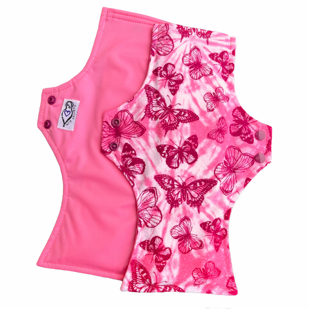 Two reusable menstrual pads with squared top and flared bottom shape against a white background. The pad on top is made from light pink and white tie dye cotton flannel with maroon butterflies. The pad on the bottom is made from raspberry pink PUL fabric and has a white "Scarlet Eve" label.