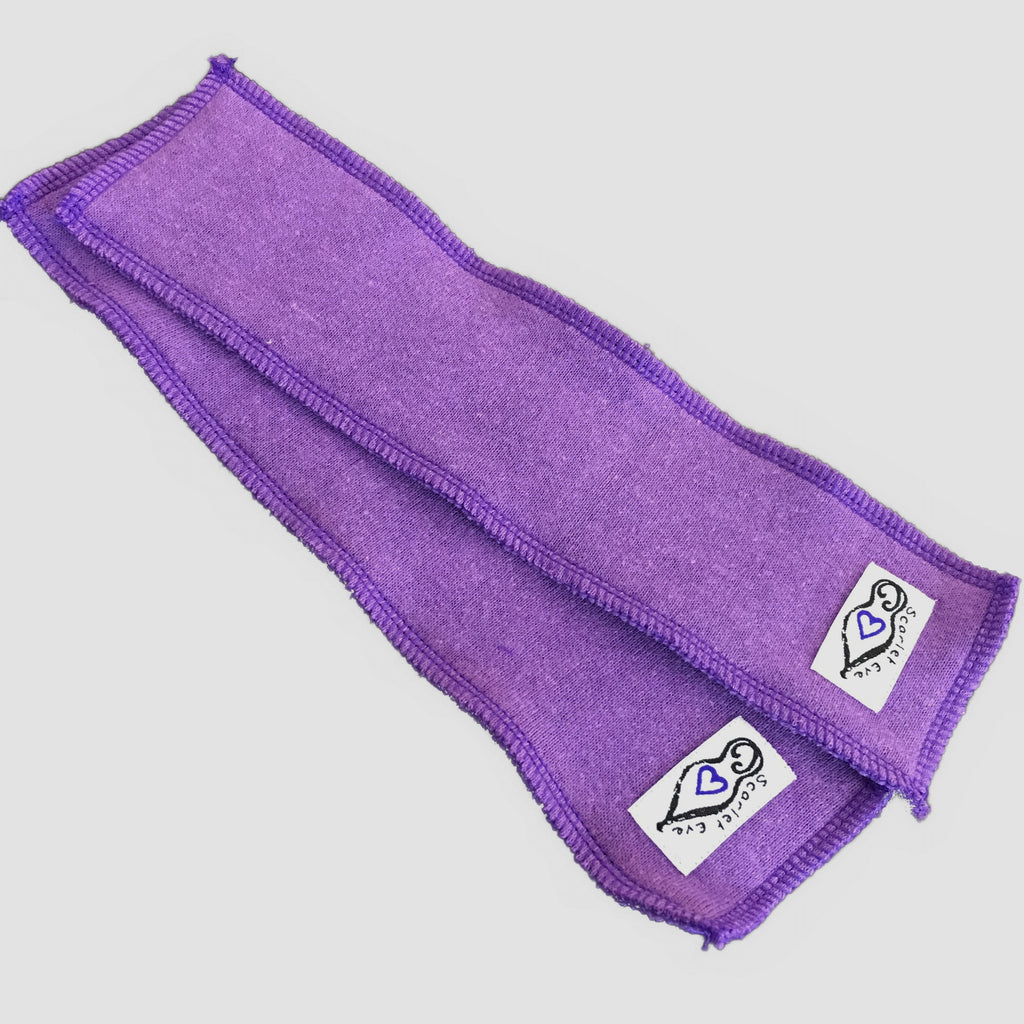 Two rectangular fleece boosters with white "Scarlet Eve" labels, against a white background. The boosters are made from purple fleece with purple overlocking.