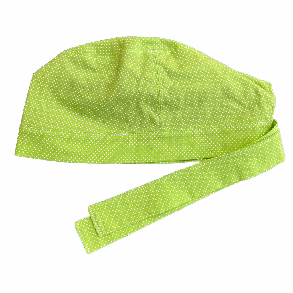 A green and white scrub cap against a white background. The cap, bottom band and ties are made from apple green woven cotton with very small white dots.