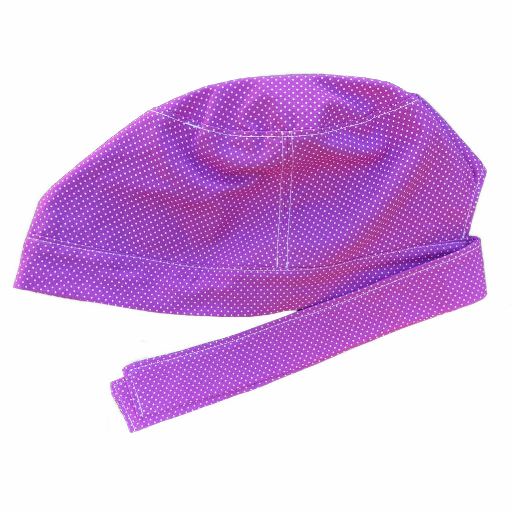 A violet and white scrub cap against a white background. The cap, bottom band and ties are made from violet woven cotton with very small white dots.