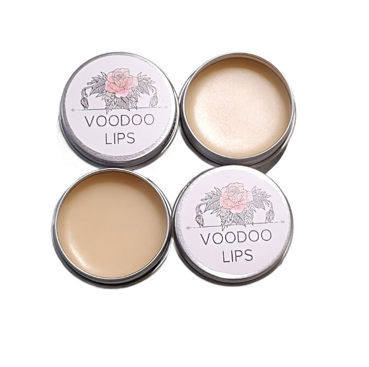 Two open tins and two lids against a white background. The tins have light pink balm inside, and the lids have a white label with black text that reads "VOODOO LIPS".